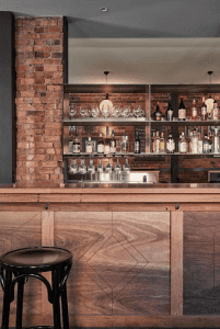 A Bar, with a palette of recycled timber, black steel and honed stone